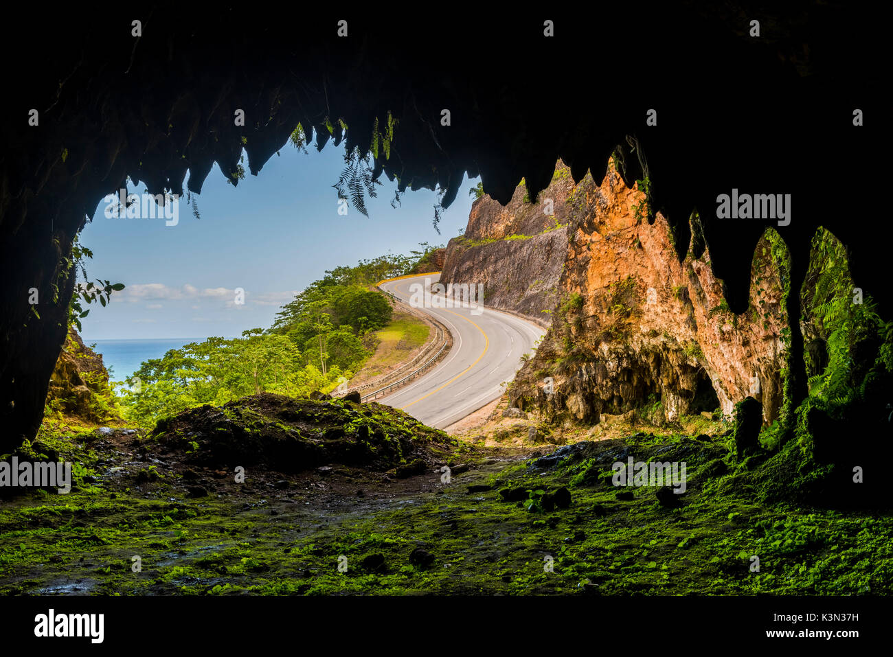 Penisola di Samana, Repubblica Dominicana. Sinuosa strada costiera si vede da una grotta di montagna. Foto Stock
