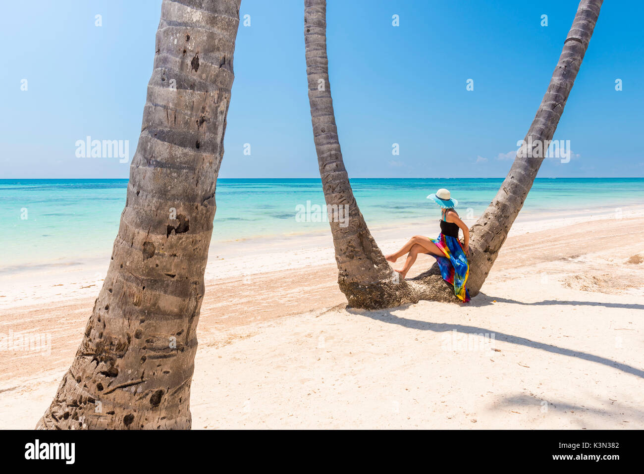 Spiaggia Juanillo (playa Juanillo), Punta Cana, Repubblica Dominicana. Donna sotto alte palme sulla spiaggia (MR) Foto Stock