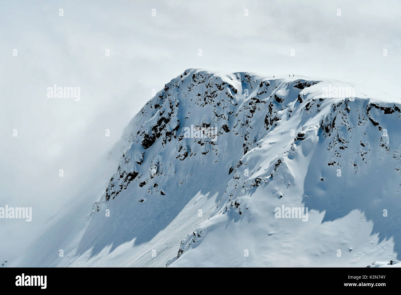 Gli sciatori sulla cima della montagna con le nuvole sullo sfondo, Valle di Gressoney, Valle d'Aosta, Italia, Foto Stock
