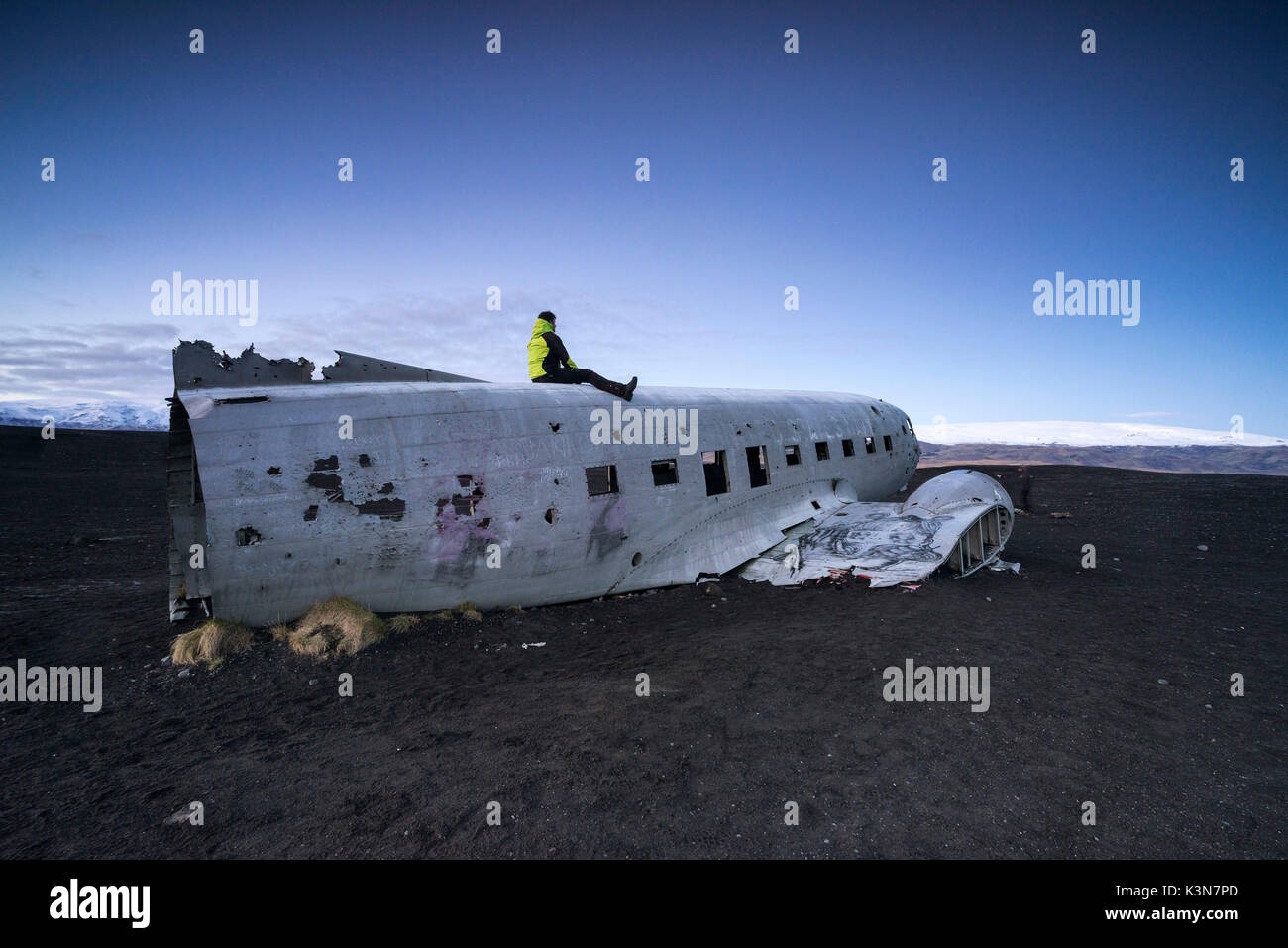 L'uomo sulla sommità del abbandonato US Navy piano DC sulla spiaggia di Solheimasandur, Sudurland, Islanda, Europa Foto Stock