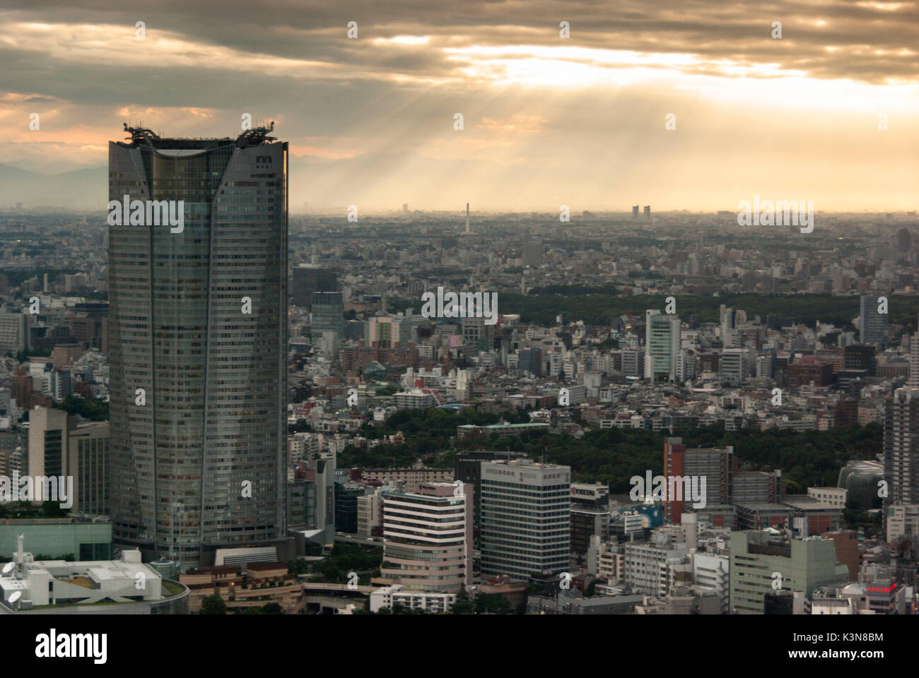 I raggi del sole che filtra attraverso le nuvole sopra la città di Tokyo Foto Stock