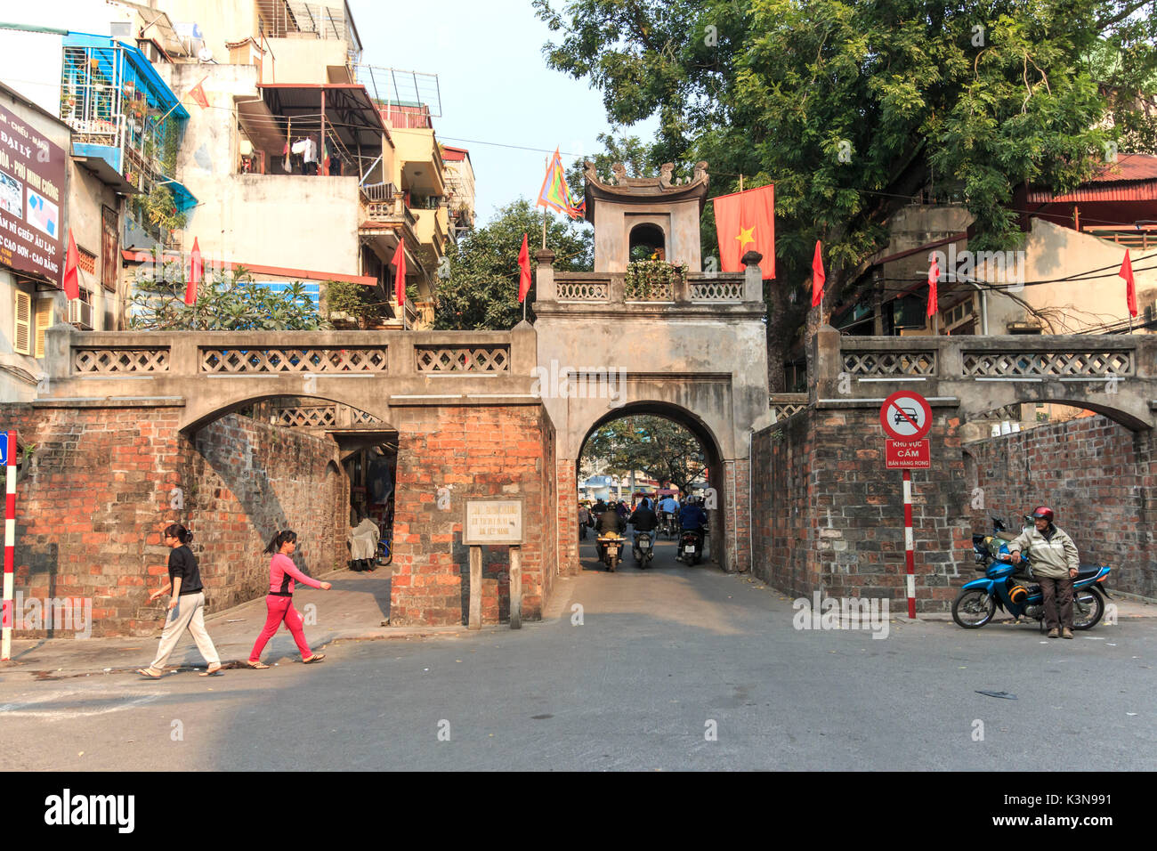 La gente a piedi nella parte anteriore della Quan Chuong Gate nel quartiere vecchio di Hanoi Foto Stock
