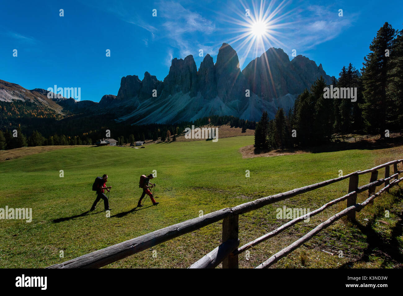 Odle,Funes, Dolomiti,Trentino Alto Adige, Italia due escursionisti fotografato mentre essi passano attraverso la valle al di sotto delle Odle. In primo piano una recinzione Foto Stock