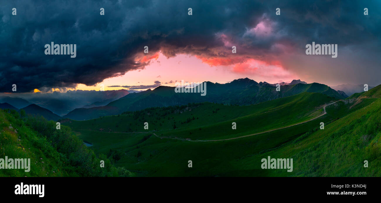 Passo Crocedomini, Parco Adamello,Lombardia,Italia i colori del tramonto tra le nuvole di due tempeste. Foto panoramica della valle sotto il Passo Crocedomini Foto Stock