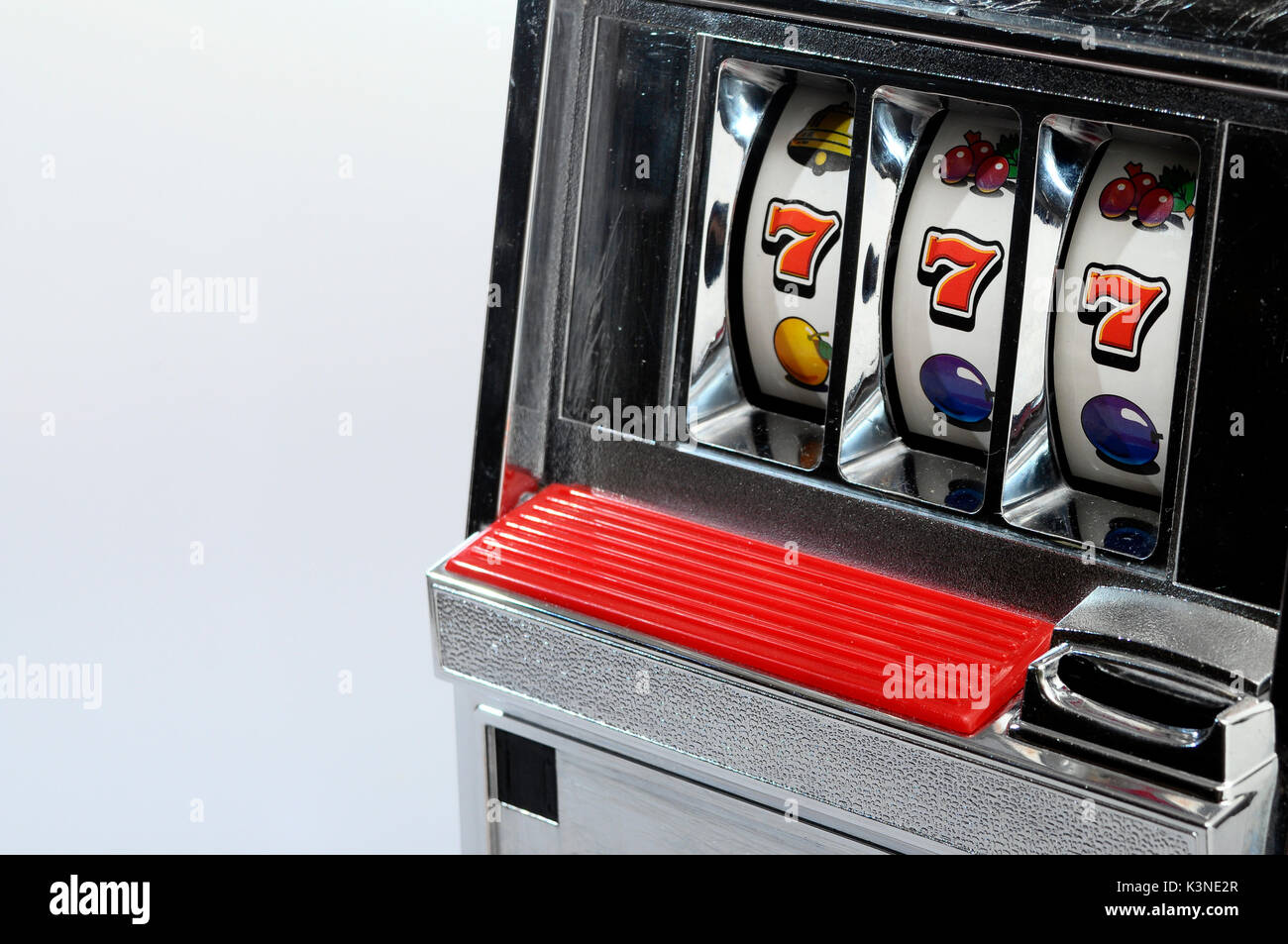 Slot machine a jackpot e tre sette su sfondo chiaro Foto Stock