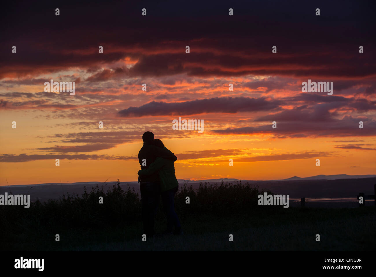 Un paio di coccolare come guardare il tramonto dal picco Coaley nel Gloucestershire. Foto Stock