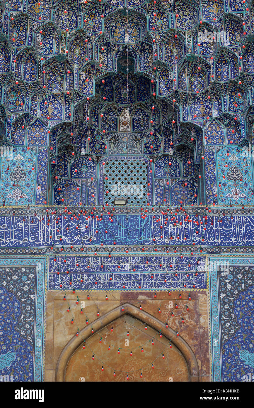 Dettaglio architettonico di iwan alla Moschea di Jaame Abbasi. Isfahan, Iran. Calligrafia coranica scritta in Thuluth script. Luci per la festa. Foto Stock