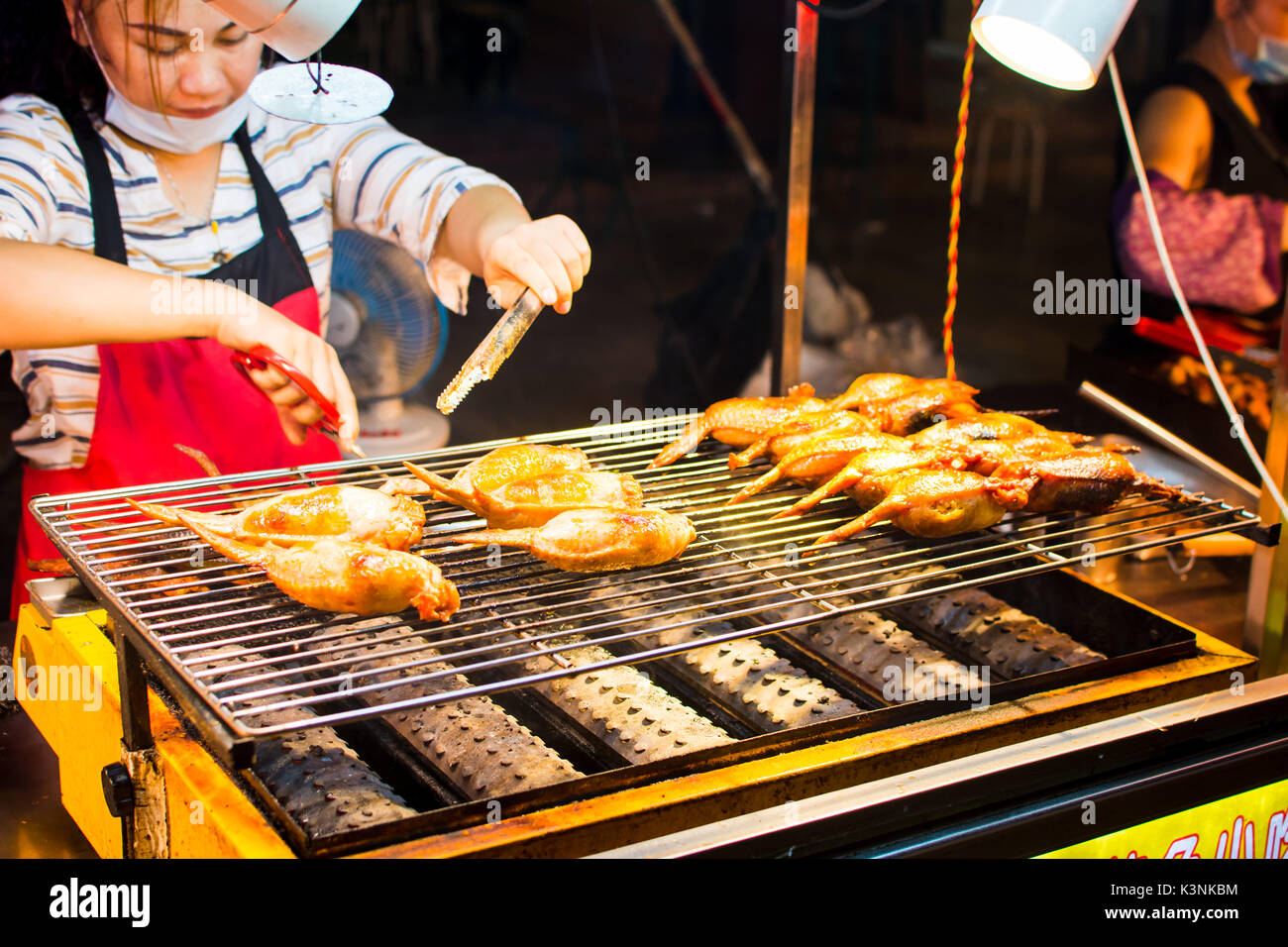 NANNING, Cina - 9 giugno 2017: Cinese lo chef prepara barbecue in Zhongshan Snack Street, il mercato alimentare in Nanning. Questo alimento street è la bigges Foto Stock