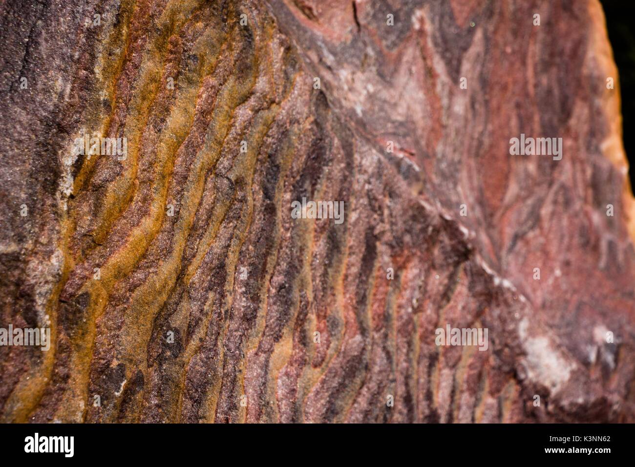 Un interessante e insolito, bella la texture del rock in onde di tonalità di colore rosso Foto Stock
