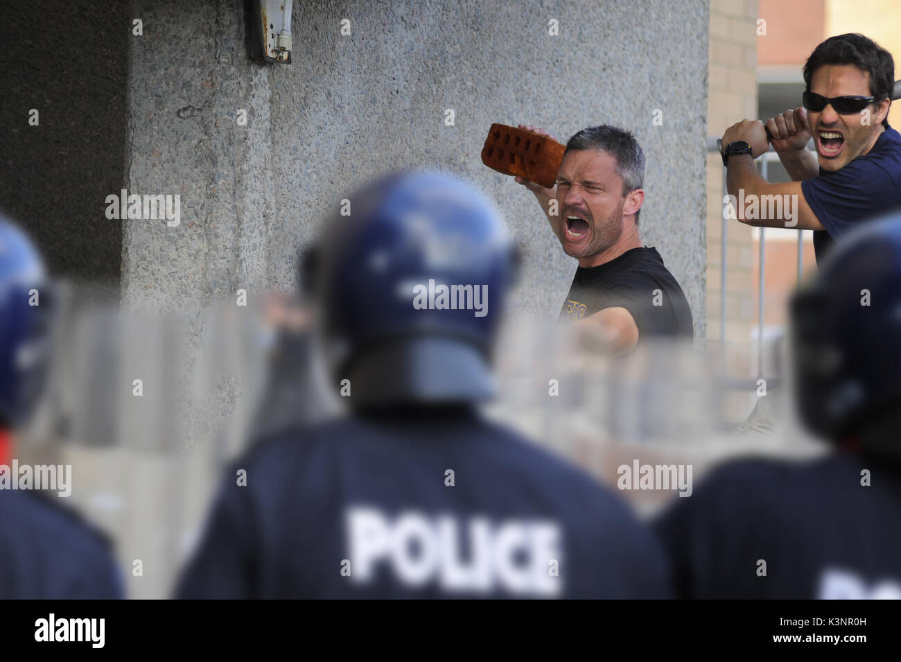 Polizia lo scenario di addestramento in azione. La polizia che viene affrontato dagli attivisti azienda mattoni. western polizia australiana. Foto Stock