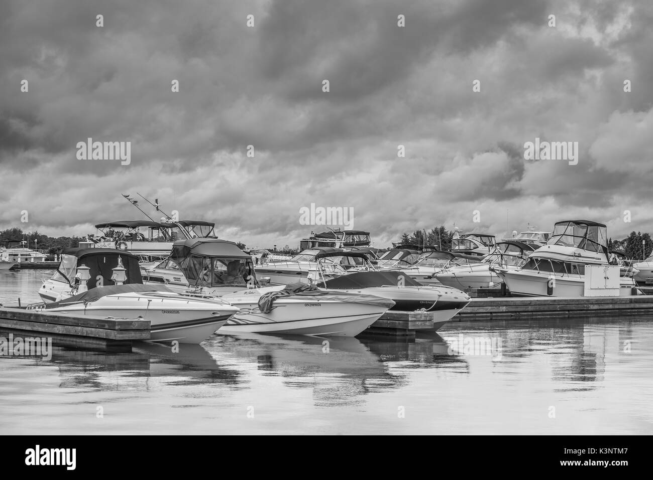 Fotografia in bianco e nero di barche ormeggiati nel porto di Orillia Ontario Canada come una tempesta passa overhead. Foto Stock