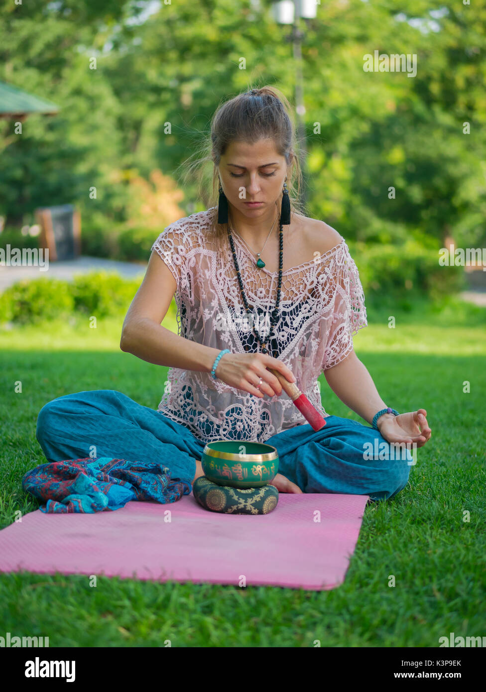 Le mani di una donna che gioca il tibetano Singing Bowl in natura. In stile  vintage. Bellissima ragazza con japa mala, materassino yoga meditazione nel  parco in estate Foto stock - Alamy