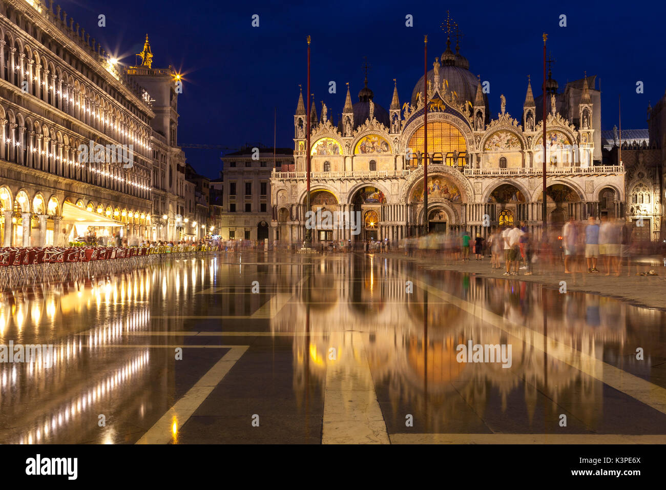 Basilica di San Marco illuminata di notte durante le ore di colore blu riflessa nell'acqua ancora di acqua alta in Piazza San Marco, Venezia , Veneto, Italia con Foto Stock