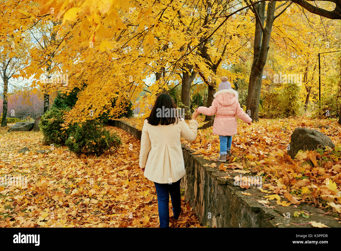 La madre cammina con un bambino nel parco in autunno. Foto Stock