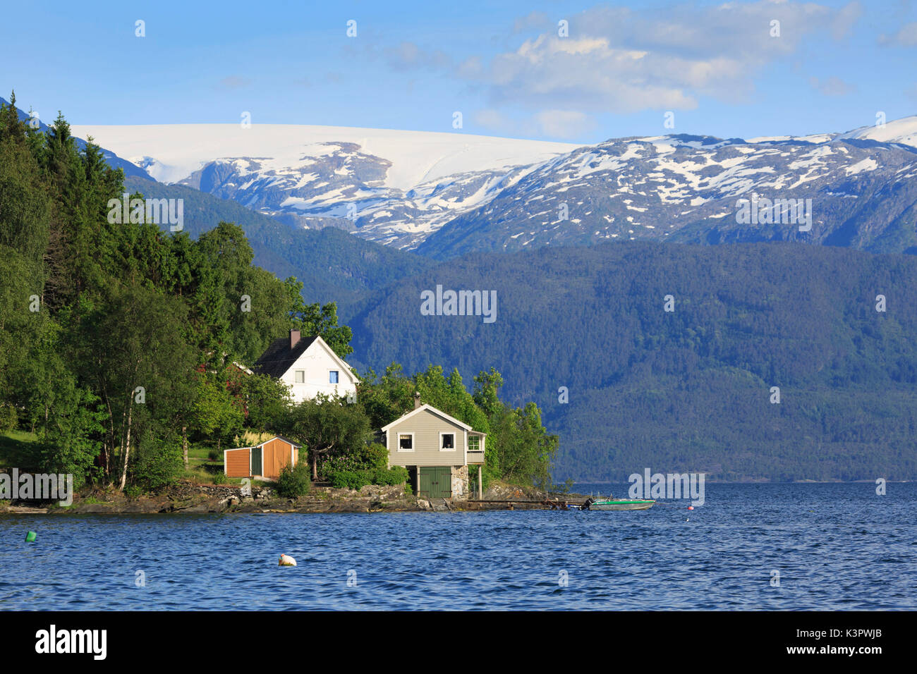 Case sul Hardangerfjord nella parte anteriore del ghiacciaio Folgefonna, Hordaland, Norvegia Foto Stock