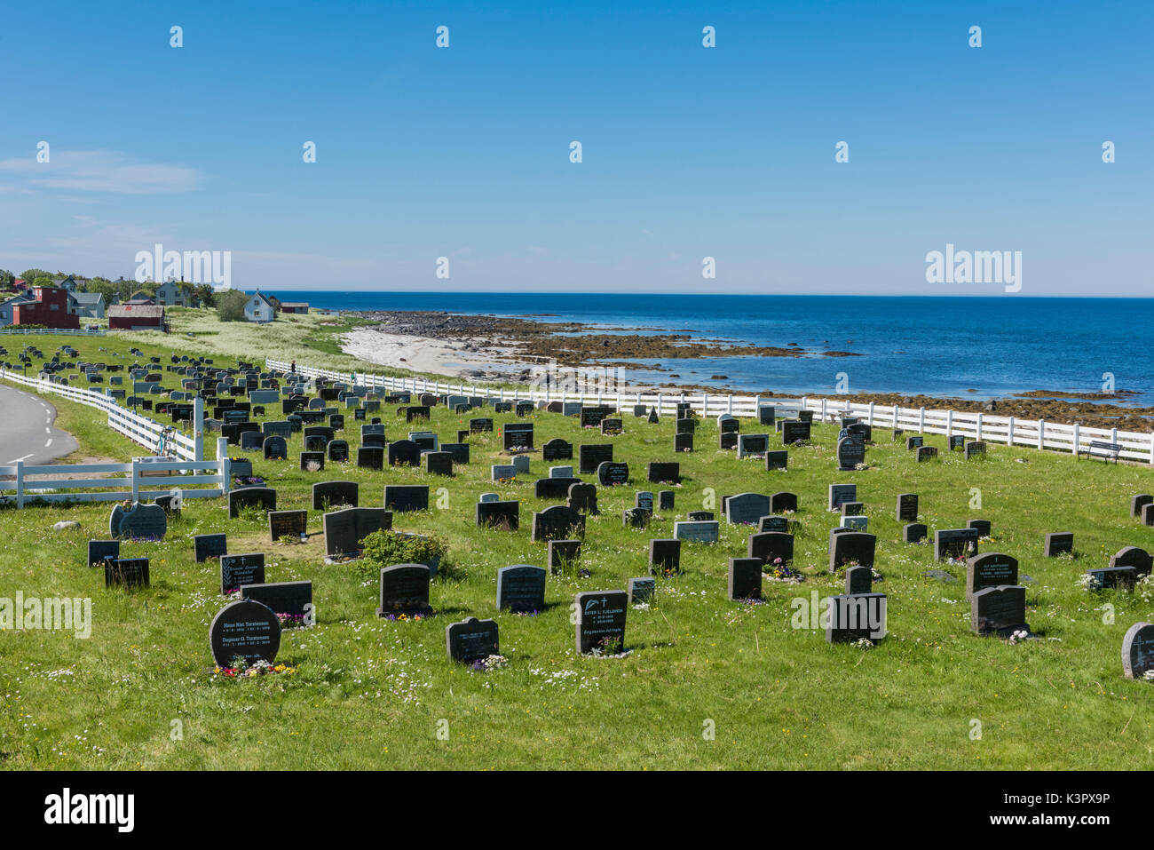 Cimitero nel verde dei prati circondati da mare blu isola Vaeroy Nordland county arcipelago delle Lofoten in Norvegia Europa Foto Stock