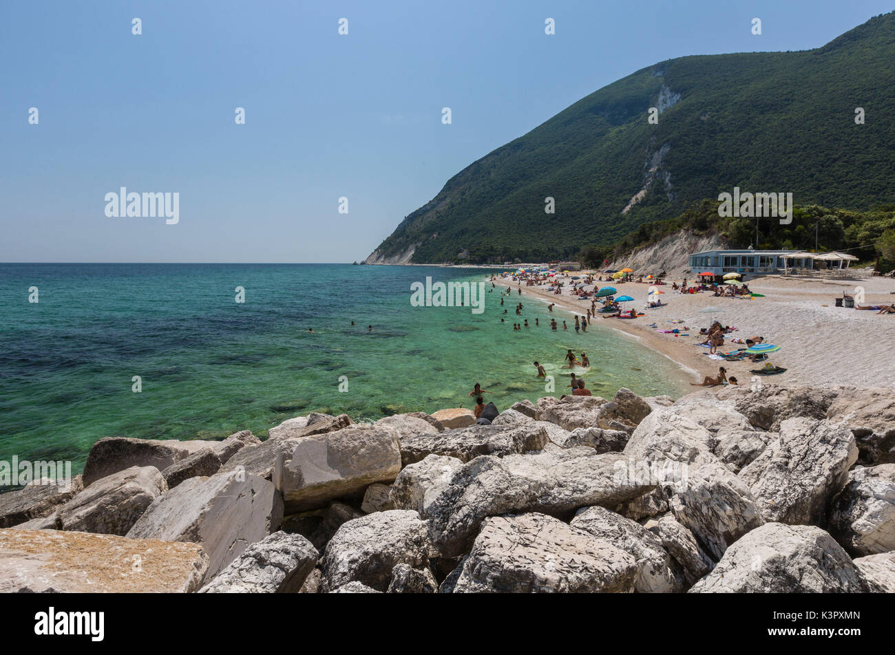 I turisti sulla spiaggia incorniciata da un mare turchese provincia di Ancona Riviera del Conero Marche Italia Europa Foto Stock