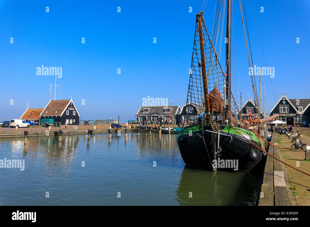 Barche da pesca in canal incorniciato dalle tipiche case di legno in primavera Marken Waterland Olanda settentrionale dei Paesi Bassi in Europa Foto Stock
