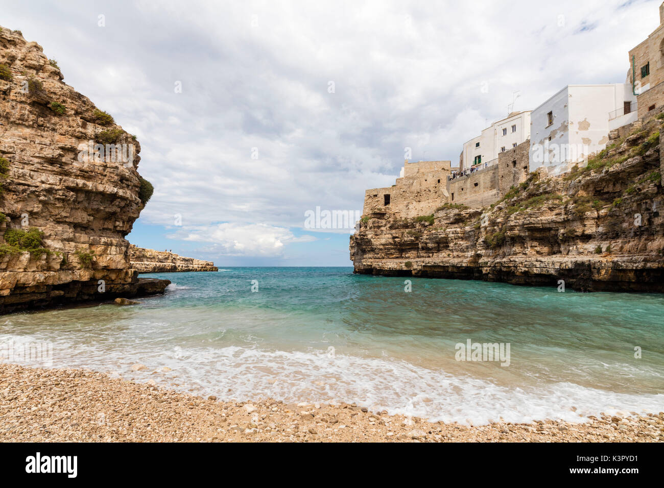 Il mare turchese incorniciata dal centro storico arroccato sulle rocce a Polignano a Mare in provincia di Bari Puglia Italia Europa Foto Stock