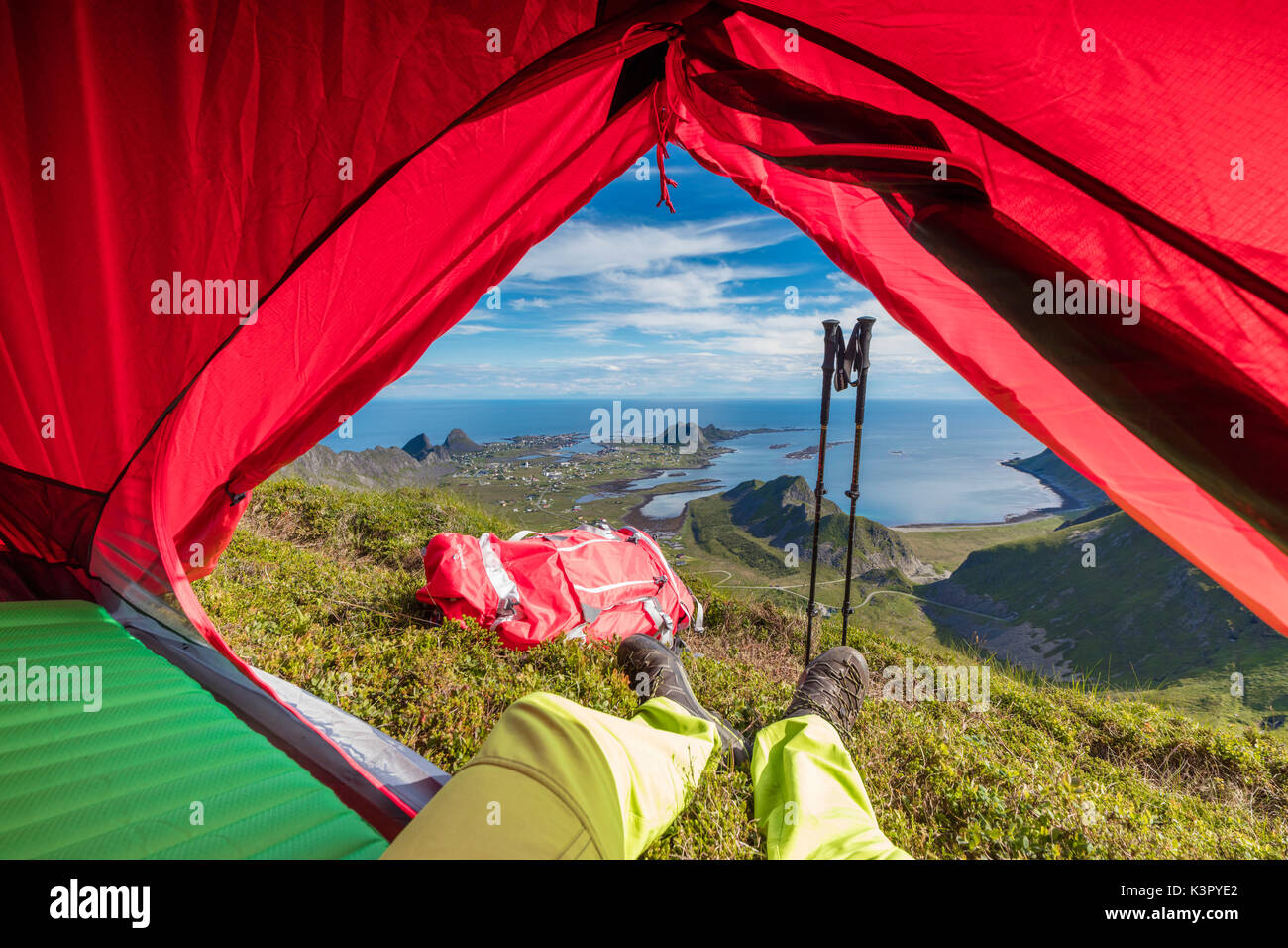 La tenda e escursionista sulla cima della montagna che si affaccia sul mare Sorland Vaeroy Isola Nordland county arcipelago delle Lofoten in Norvegia Europa Foto Stock