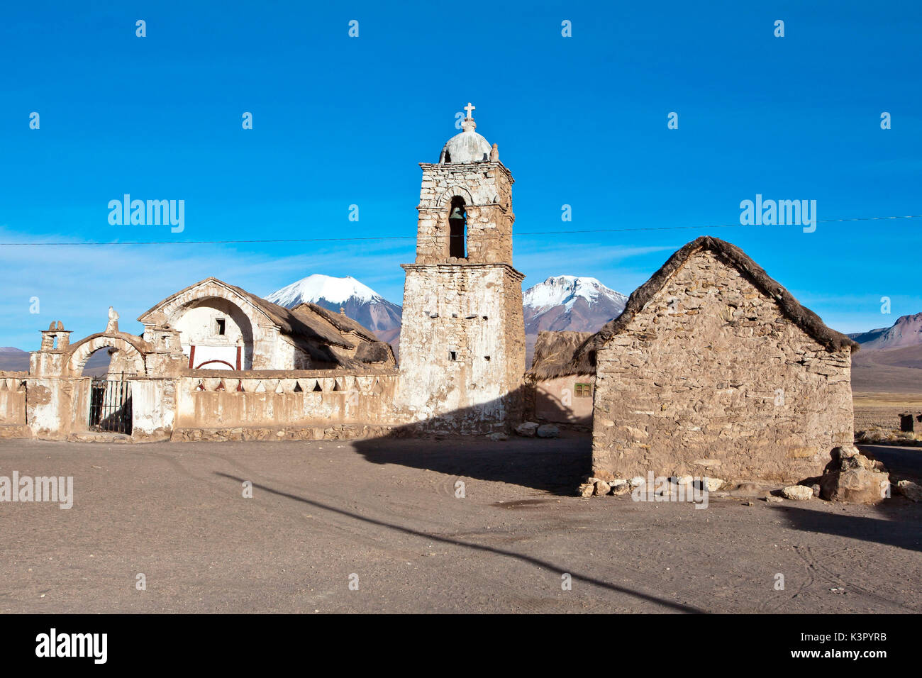 La chiesa di Sajama e vulcano Parinacota e Pomerape (Les Nevados de Payachatas). Il Sajama Pueblo, in Sajama Parco Nazionale, è il punto di partenza della salita del Nevado Sajama, il picco più alto in Bolivia (6542m) - Bolivia, Sud America Foto Stock