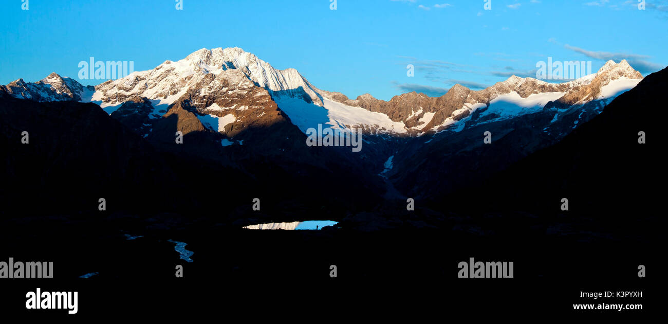 Dawn è uno dei miglior momento per i fotografi: silhouette, luce e ombra, riflettendo i laghi e vette innevate, come il Monte Disgrazia in questo esempio, sono ingredienti perfetti per un'immagine in questo momento della giornata - la Valmalenco Lombardia Italia Europa Foto Stock