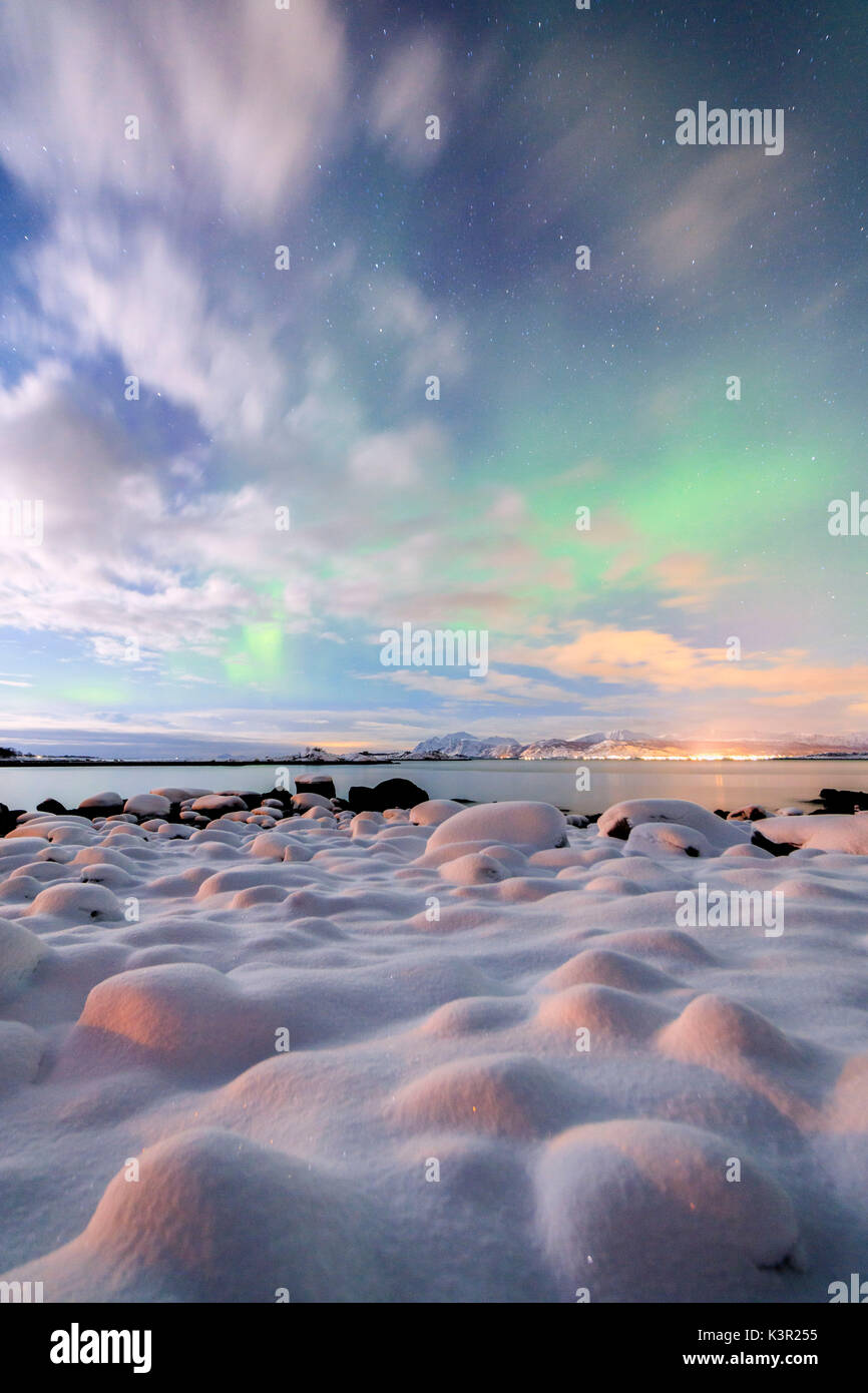 La luce rosa e l'aurora boreale illumina il paesaggio innevato su una notte stellata Strønstad Isole Lofoten in Norvegia Europa Foto Stock