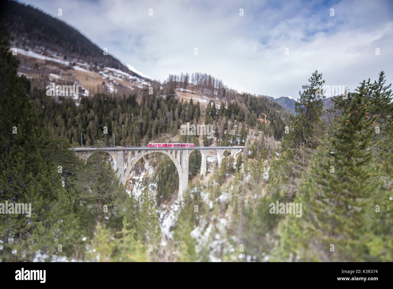 Bernina Express passa attraverso Wiesner Viadukt e boschi Filisur Cantone dei Grigioni Svizzera Europa Foto Stock