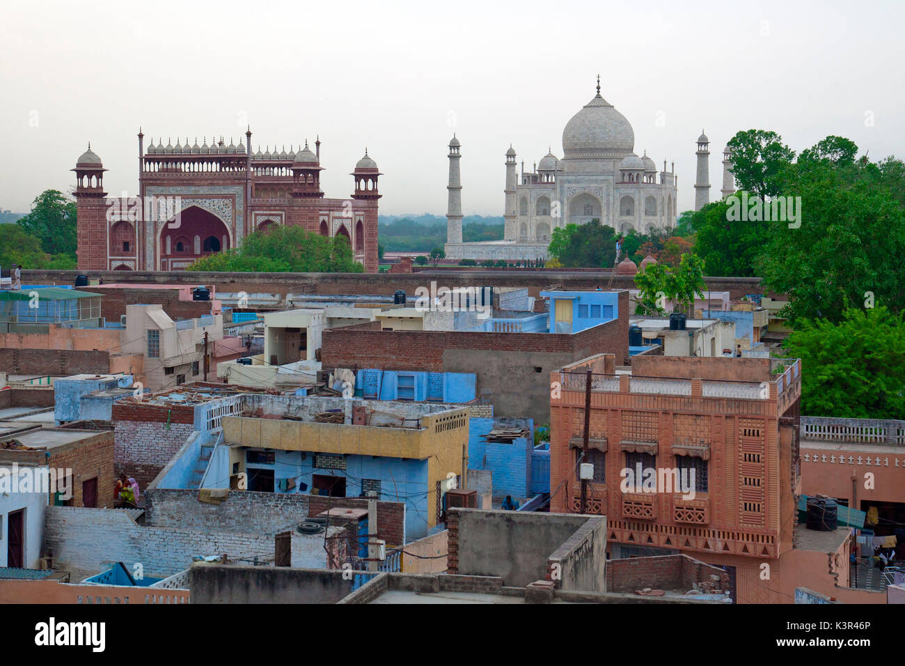 Le case dei poveri in contrasto con lo splendore del Taj Mahal Agra, India Foto Stock