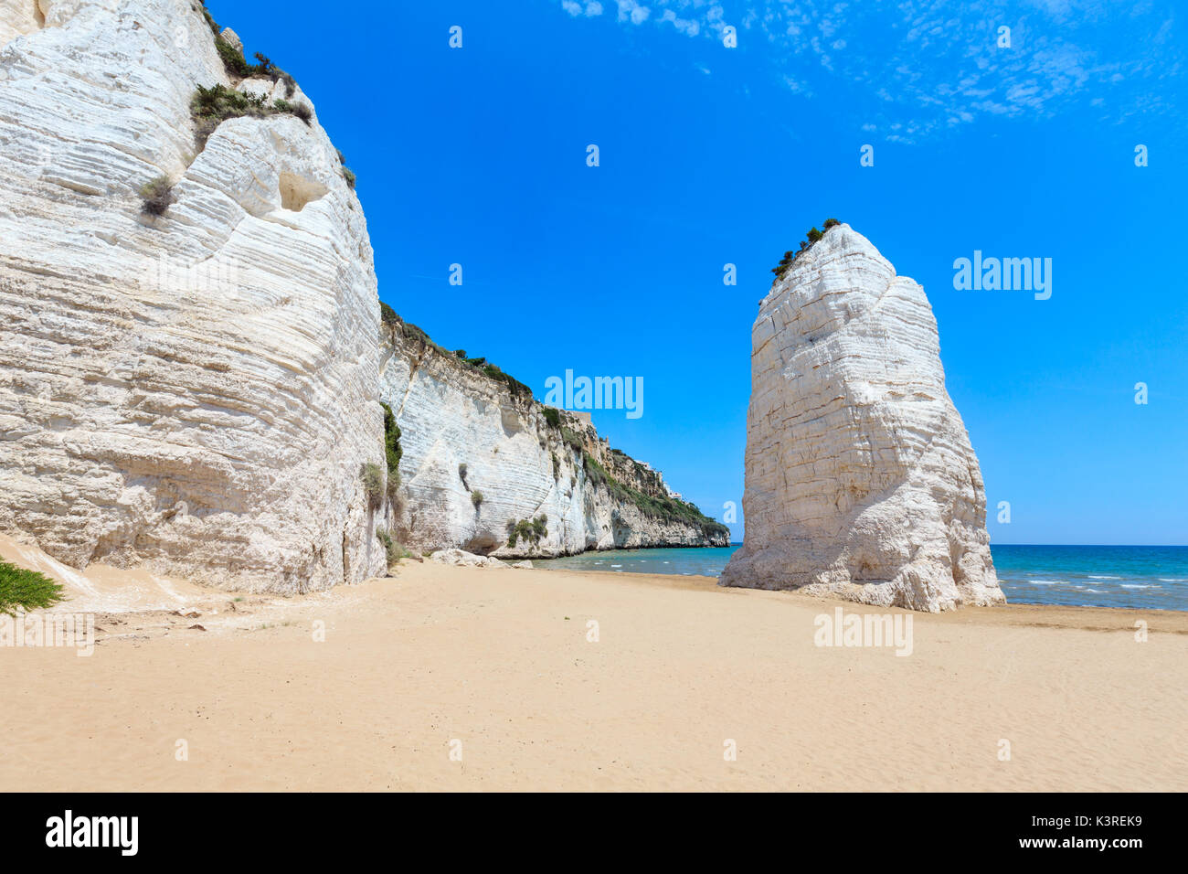 Estate pittoresca spiaggia di Pizzomunno famosa roccia bianca di Vieste, mare del Gargano in Puglia, Italia Foto Stock