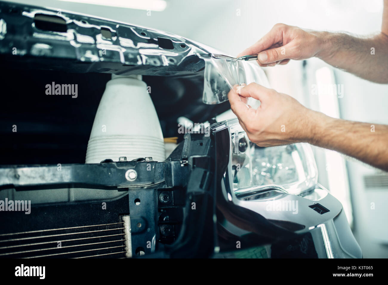 Il lavoratore professionale installare proteggere la vernice. Trasparente pellicola di protezione contro i trucioli e graffi. Rivestimento protettivo Foto Stock