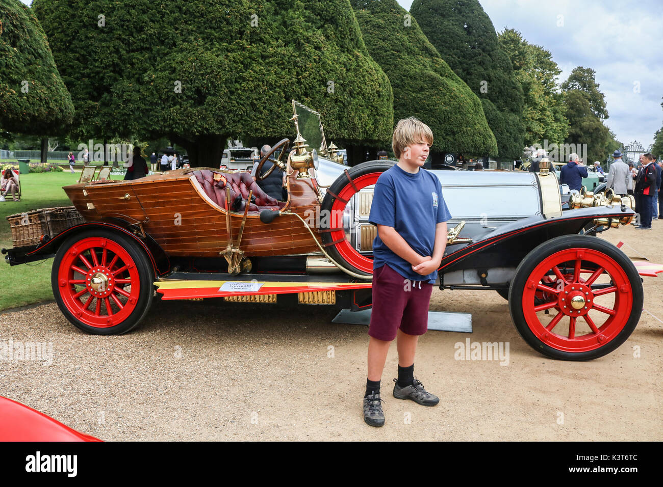 Londra Regno Unito. Il 3 settembre 2017. Un giovane visotr pone di fronte alla vettura usata nel film "chitty chitty bang bang" come parte di una collezione di rari classic vintage autovetture provenienti da tutto il mondo sono in esposizione presso il Concours de eleganza sullato motivi di Hampton Court Palace di Londra. Credito: amer ghazzal/alamy live news Foto Stock