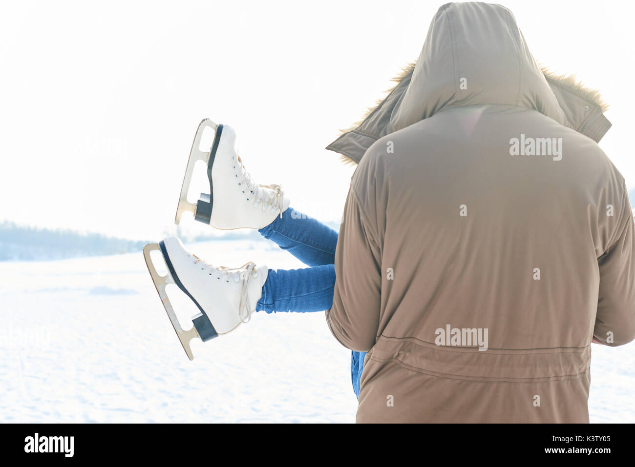 Ragazza indossando ice-pattini è divertente essere portato dal padre in inverno Foto Stock