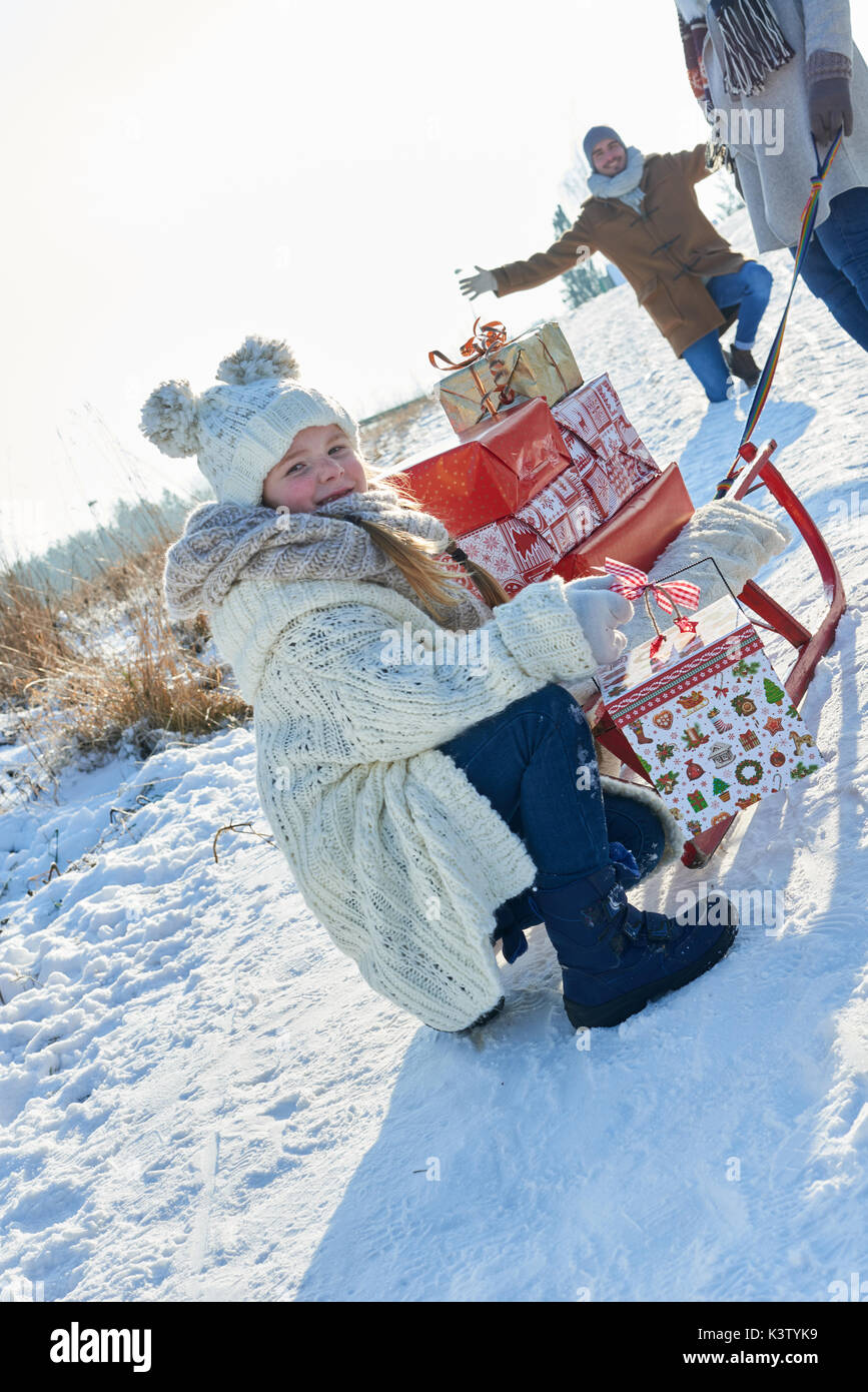 La famiglia dona molti regali di natale con slitta in inverno Foto Stock