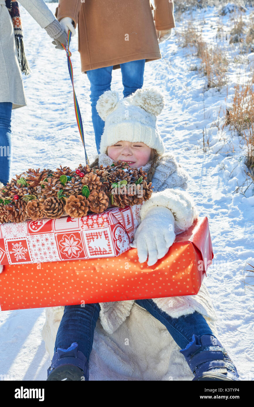 Bambina con i regali di Natale la slitta di equitazione in inverno Foto Stock