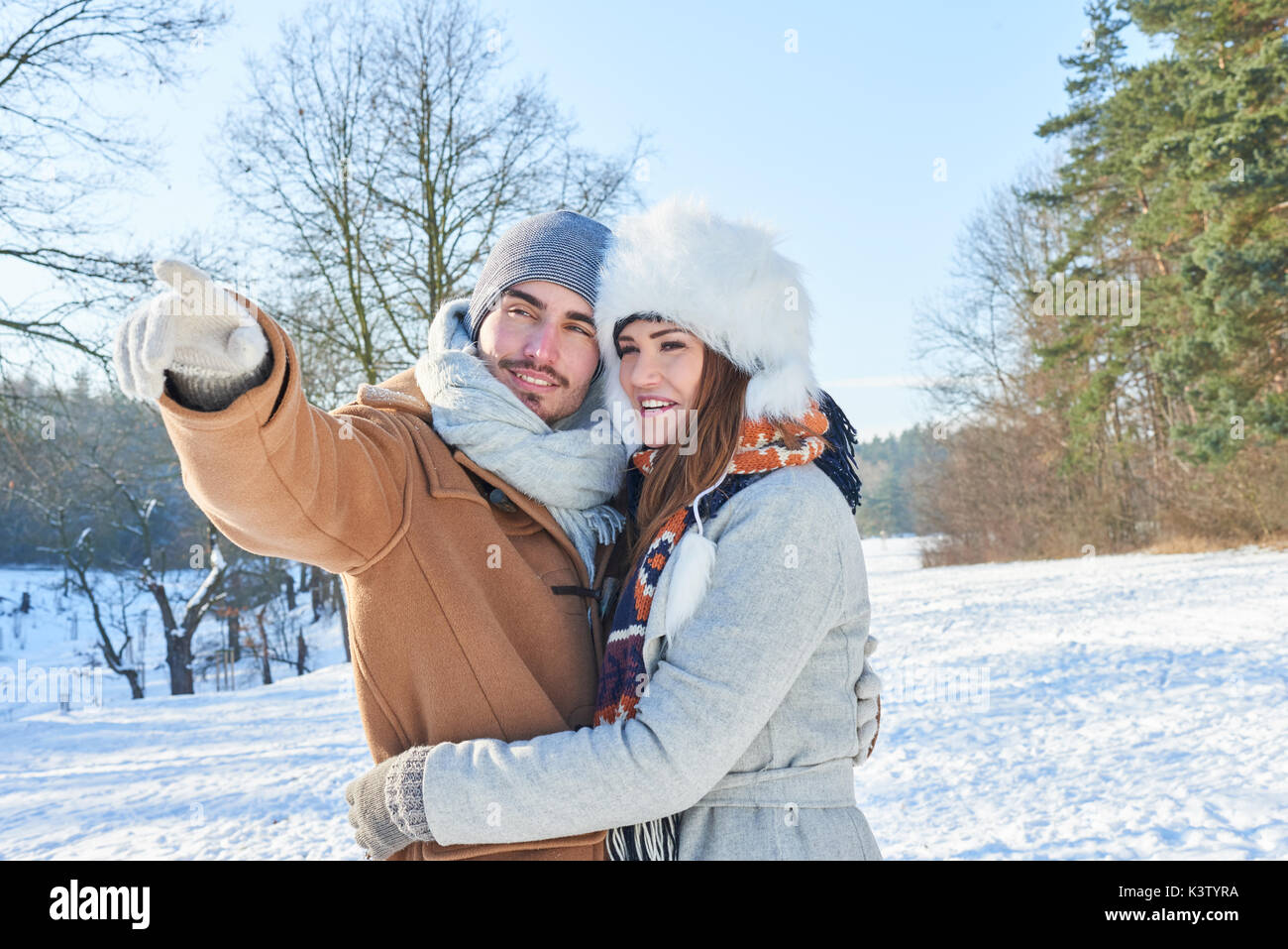 Coppia felice sulle loro vacanze invernali a piedi nel parco Foto Stock