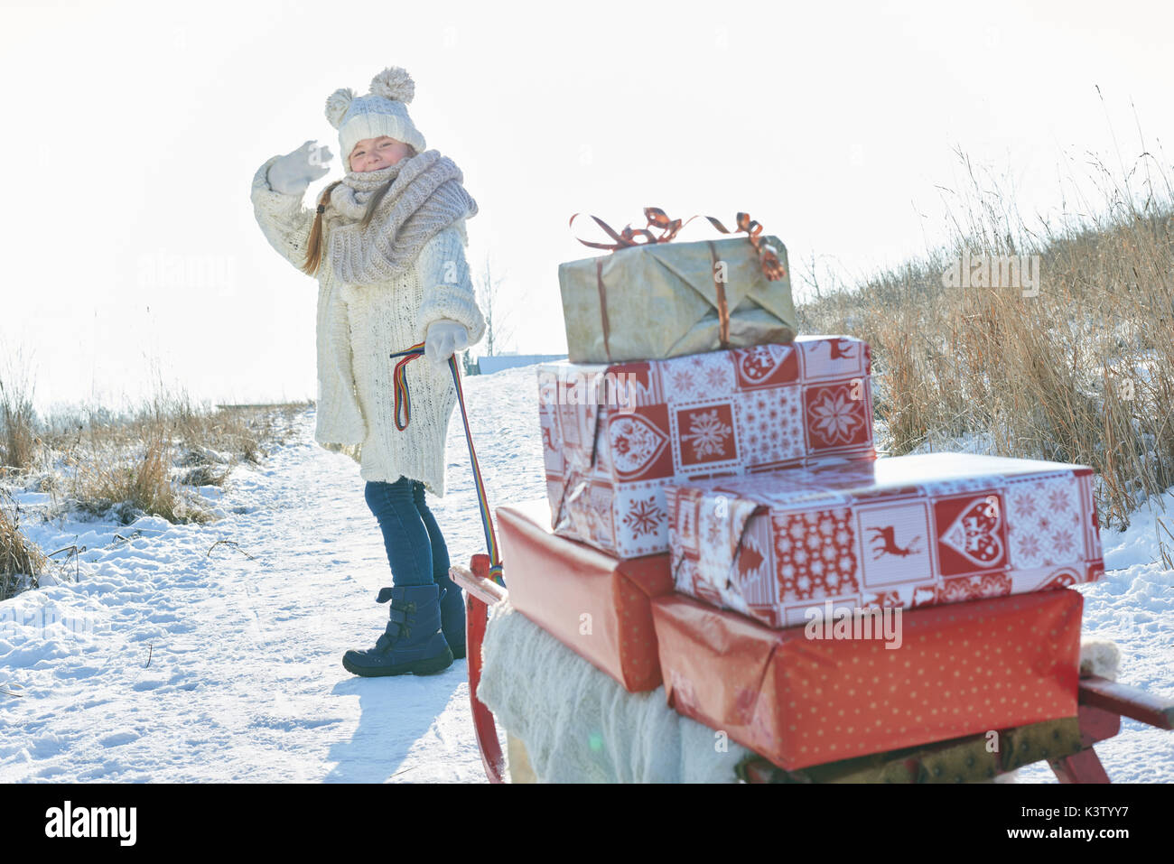 Ragazza consegnare i regali di natale con slitta in inverno Foto Stock
