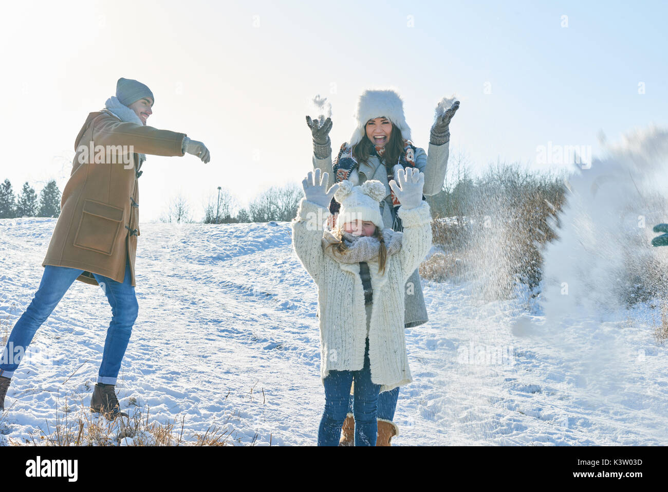 Famiglia in lotta con le palle di neve per divertirsi con gioia in inverno Foto Stock