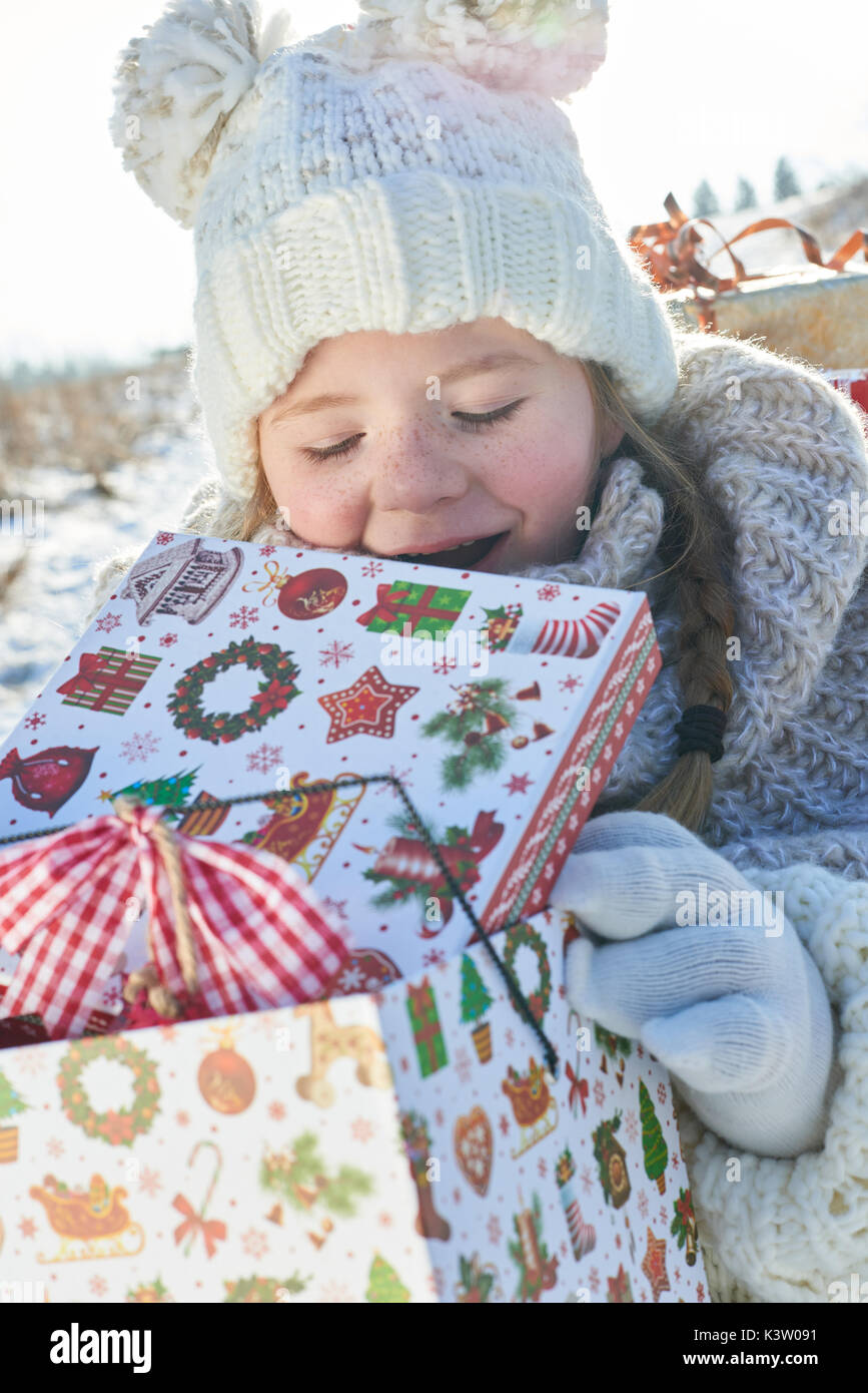Bambino spacchetta il natale presente con gioia in inverno Foto Stock