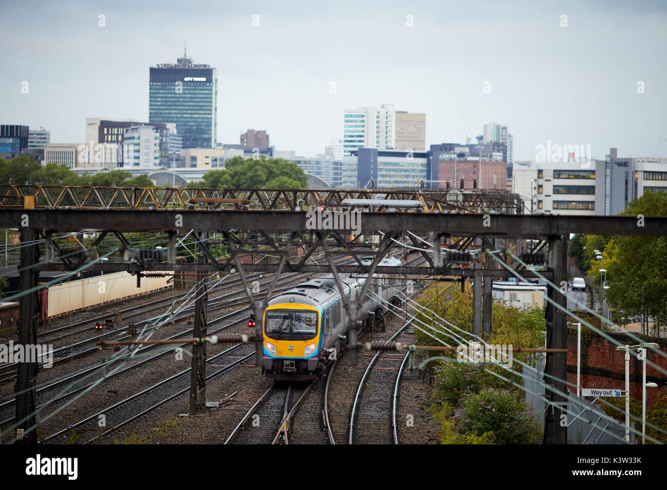 TransPennine Express unità multiple di franchising la linea ferroviaria da Ardwick che conduce alla stazione ferroviaria Manchester Piccadilly Station con skyline della città West Coast Main L Foto Stock