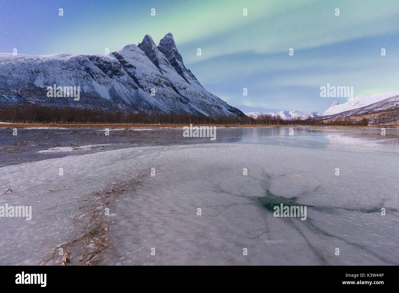 Crociera di ghiaccio impresso sulla superficie ghiacciata di un lago ai piedi dell'Otertinden. Otertinden, Signaldalen, Storfjord, Alpi Lyngen, Troms, Norvegia, Lapponia, l'Europa. Foto Stock