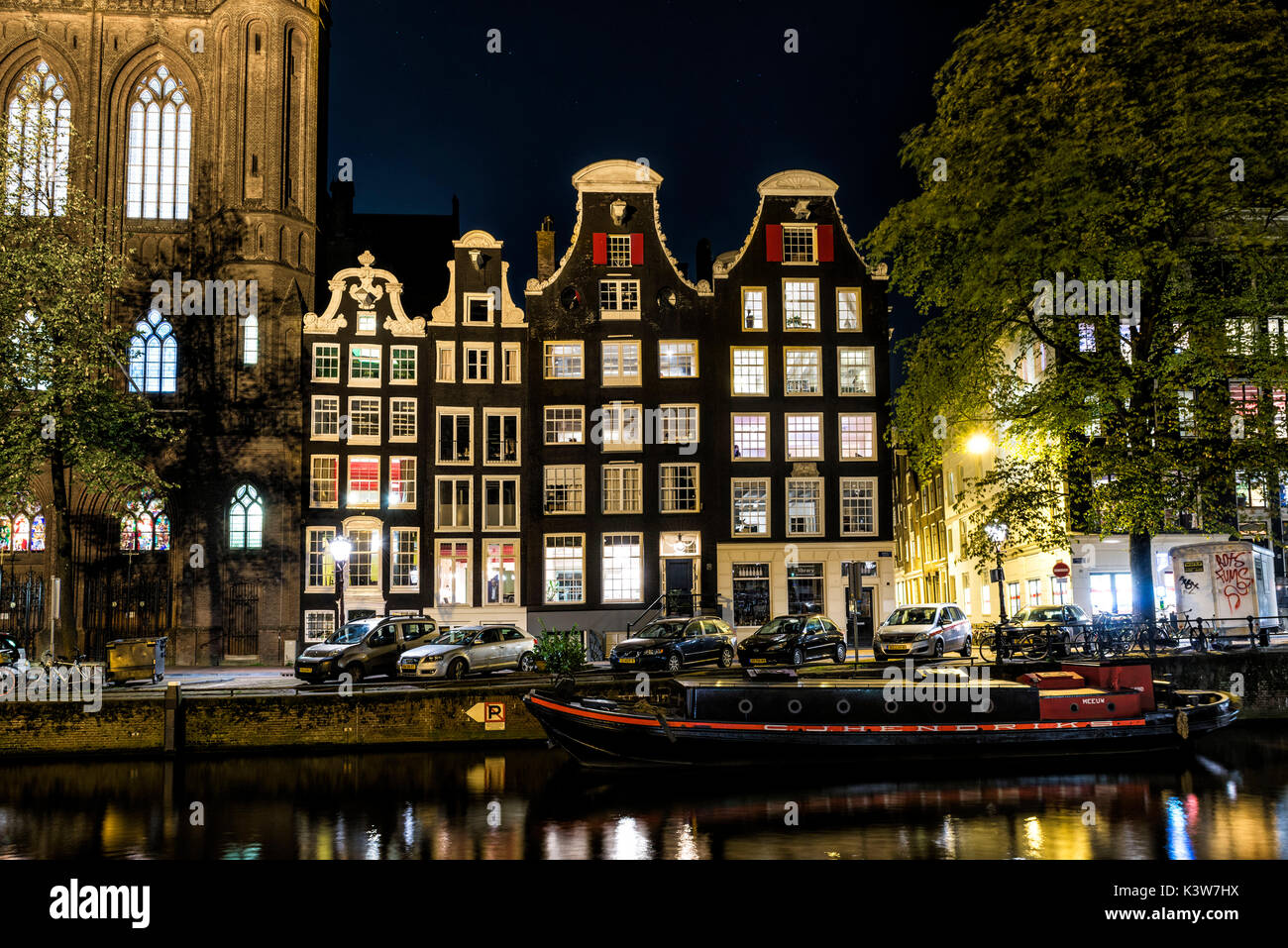 Amsterdam, Paesi Bassi, l'Europa. Tradizionali edifici vecchi riflessi di notte nel canale. Foto Stock