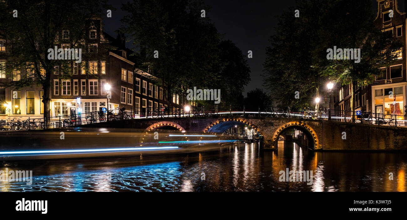 Amsterdam, Paesi Bassi, l'Europa. Canal e sentieri di luce di una imbarcazione. Foto Stock