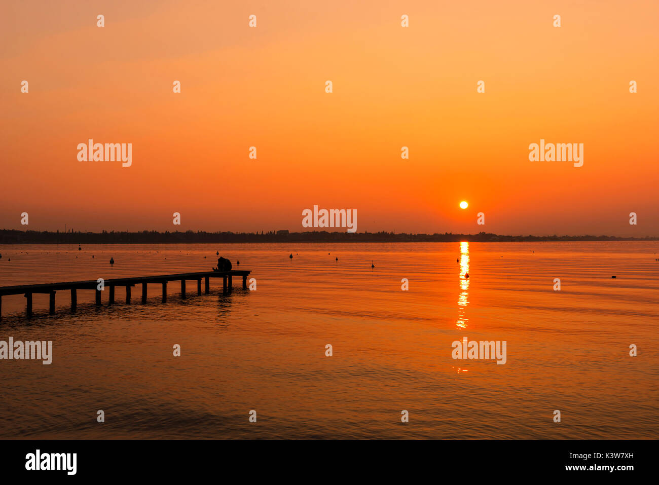 L'Italia, Veneto, Lago di Garda, amare giovane kissing al tramonto. Foto Stock