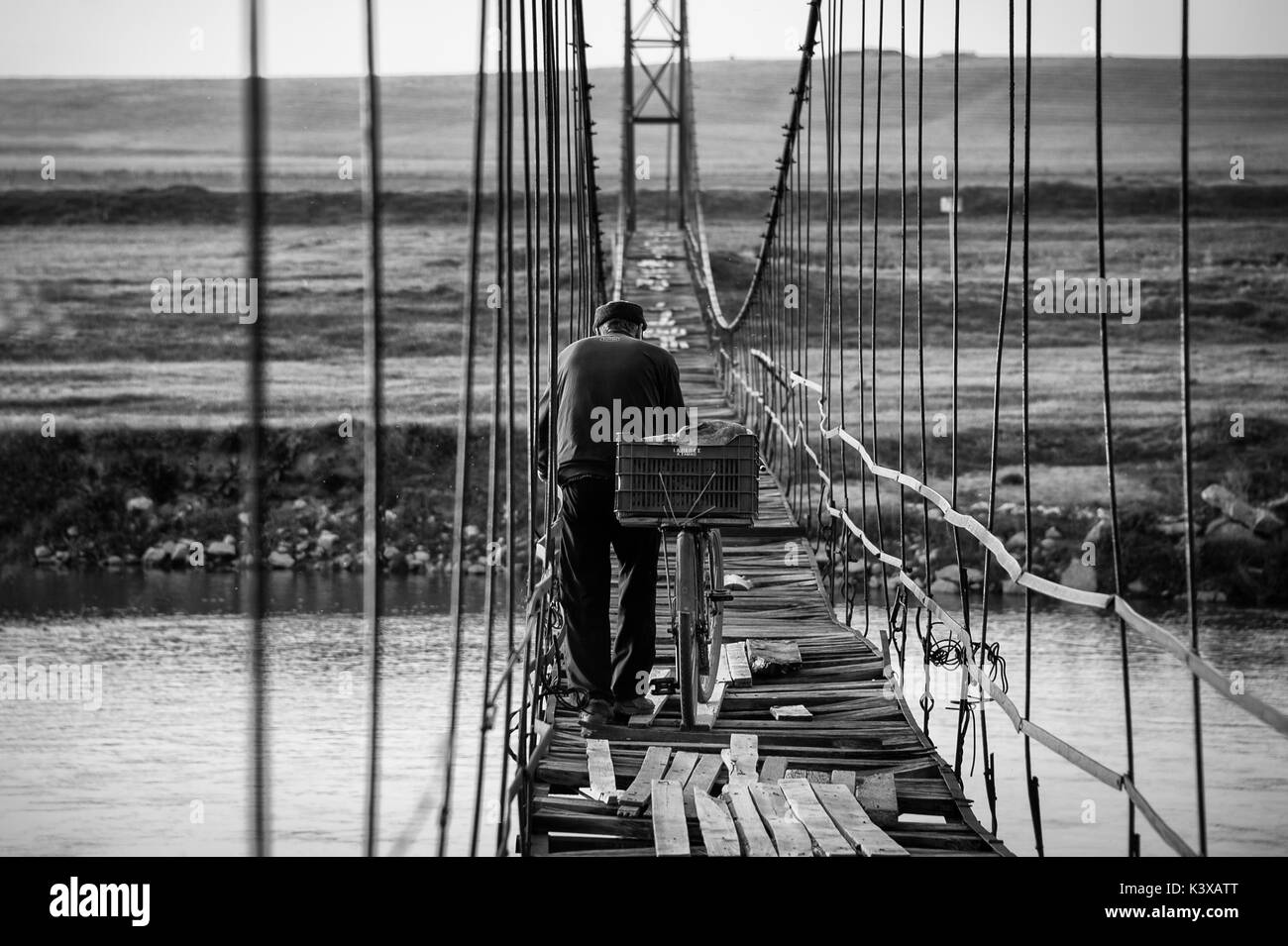 Uomo vecchio con una bicicletta attraversando il ponte Foto Stock