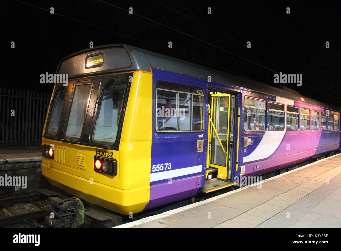 Classe Pacer 142 diesel multiple unit treno visto di notte in Lancaster stazione ferroviaria nella piattaforma di baia numero 2. Foto Stock