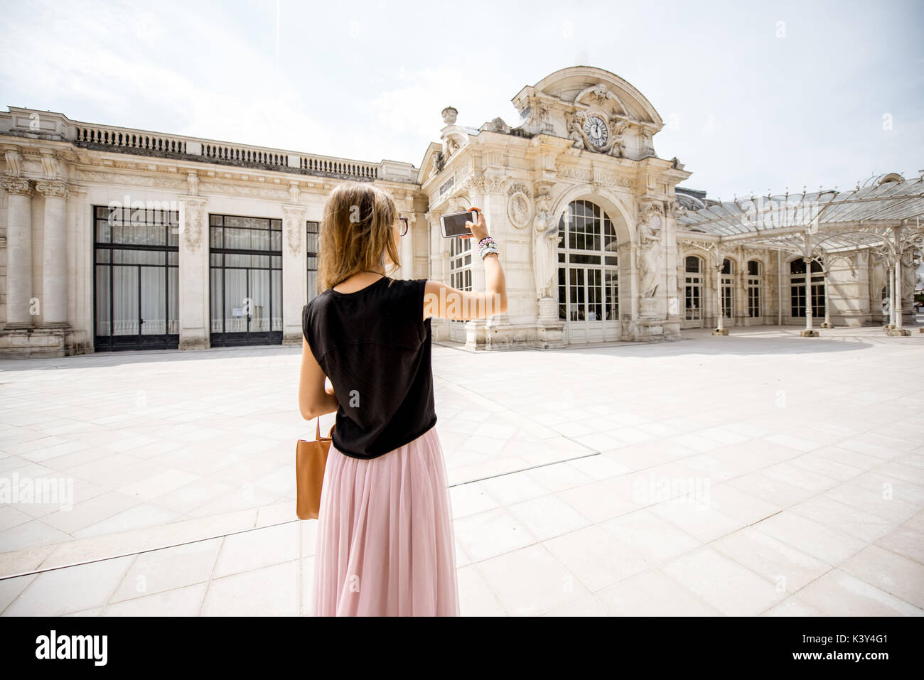 Donna vicino all'antico e bellissimo edificio nella città di Vichy, Francia Foto Stock