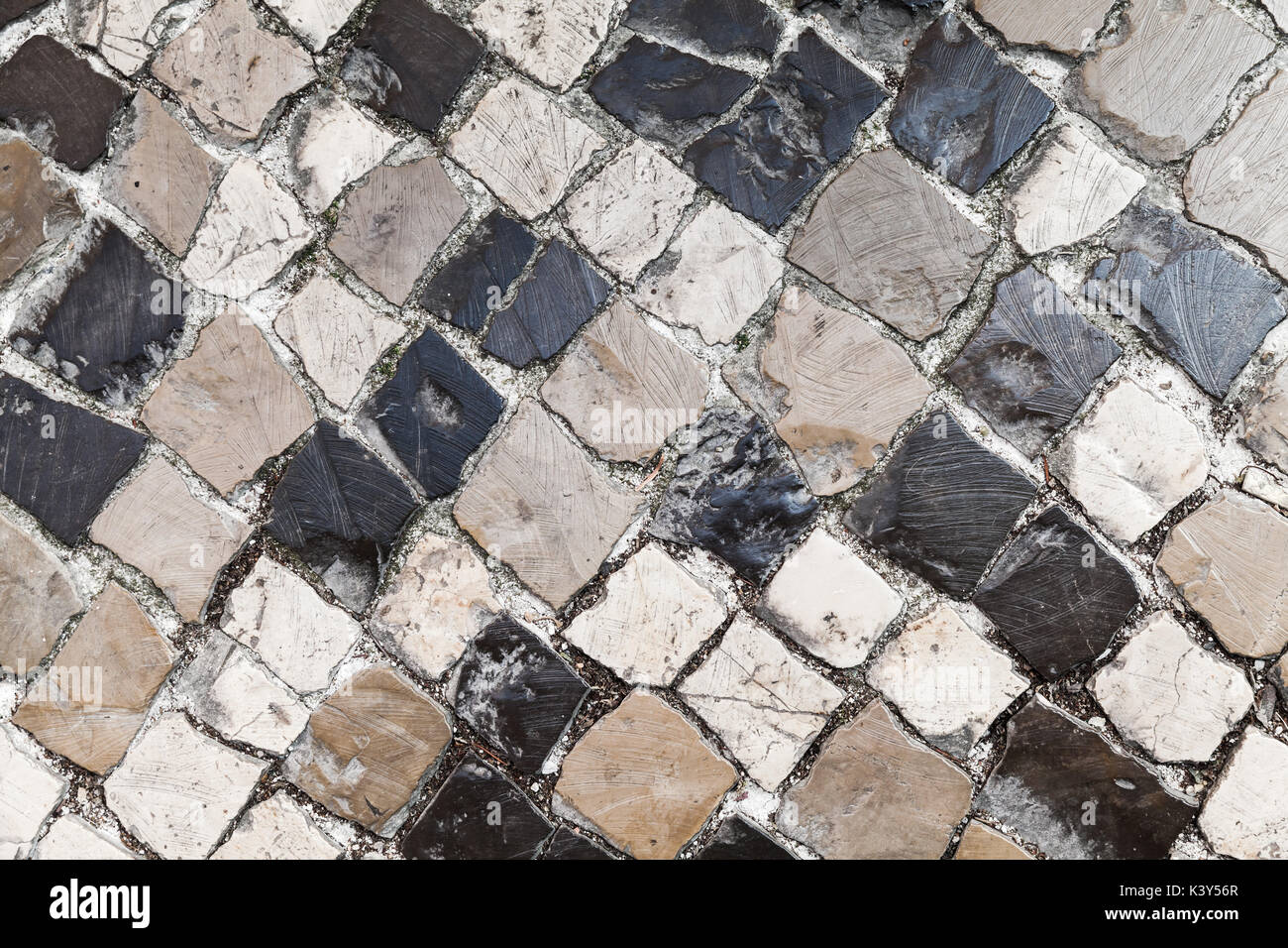 Antica pietra pavimentazione stradale, texture di sfondo. Calcada strada di ciottoli pavimento in mosaico della città di Lisbona, Portogallo Foto Stock