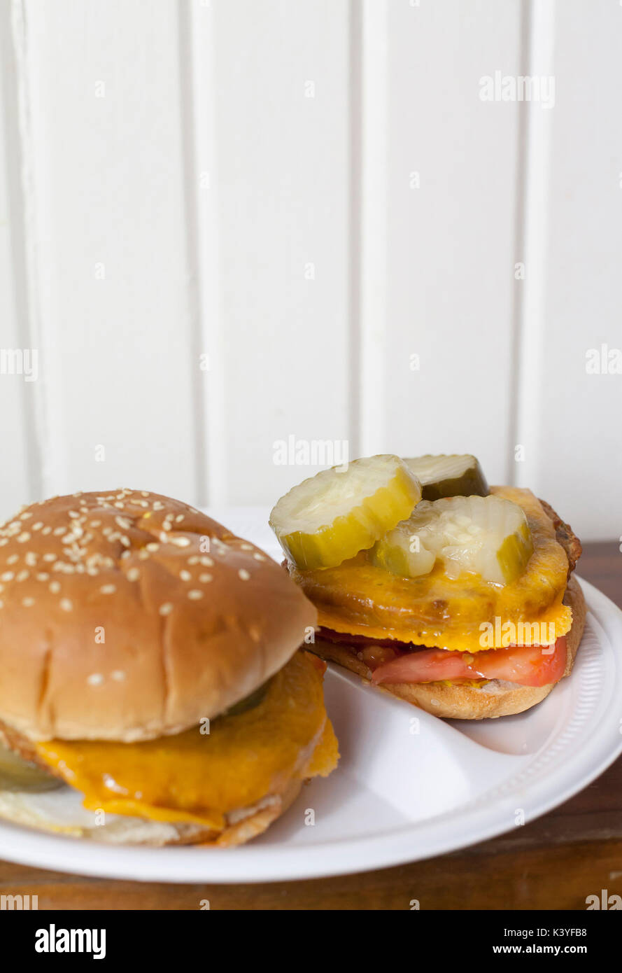 Due cheeseburger vegetariano con sottaceti e i pomodori su una piastra Foto Stock