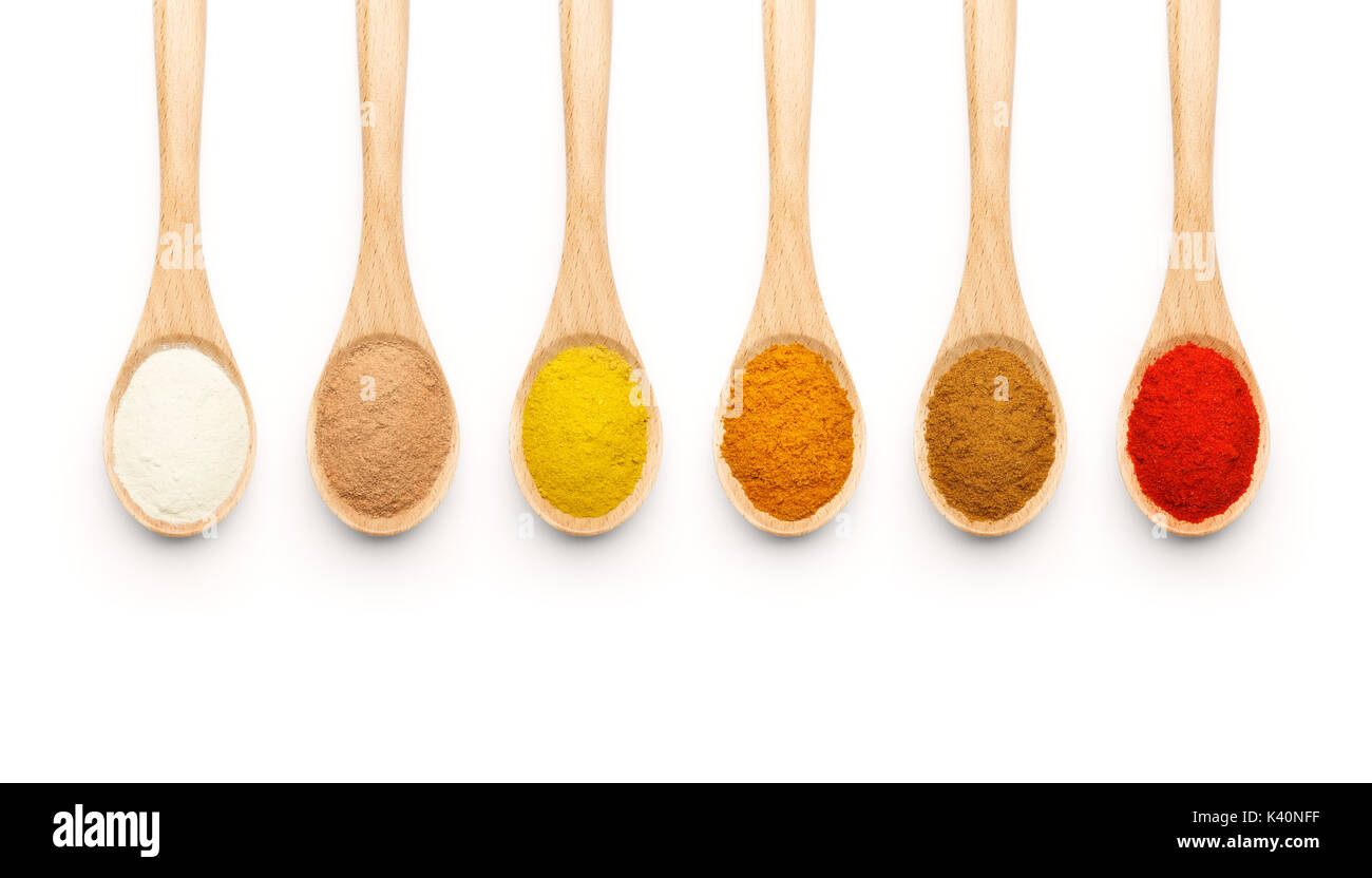 Cucchiaio di legno riempita con spezie colorate su sfondo bianco Foto Stock